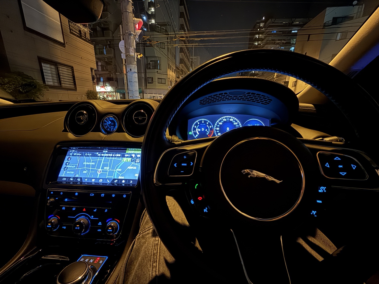 青いメーターと街灯に照らされた、夜のドライブの景色